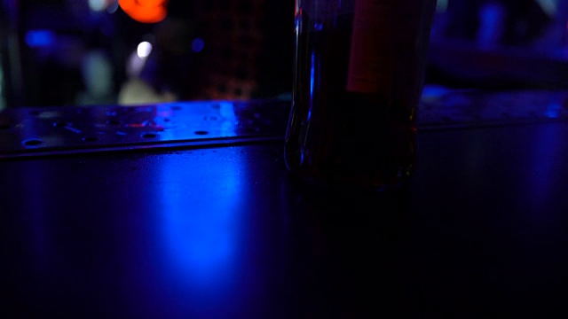 调酒师清洁吧台，并在夜总会提供一瓶啤酒，特写视频下载