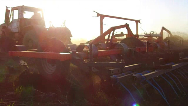 农民在拖拉机土壤犁稳定的运动农业地面俄罗斯准备土地与苗床耕作机作为预播种活动的一部分，在早春季节的农业工作在生活方式的农田。农业的概念视频素材
