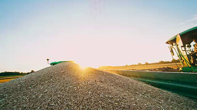 联合收割机装车与收获的小麦在农村田野，慢镜头视频素材