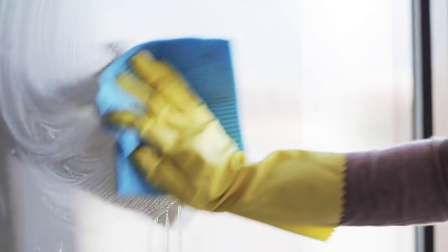 戴着手套用抹布擦窗户的女人视频素材