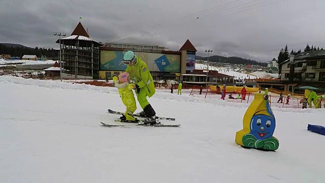 一个教练教一个小女孩如何滑雪。视频素材