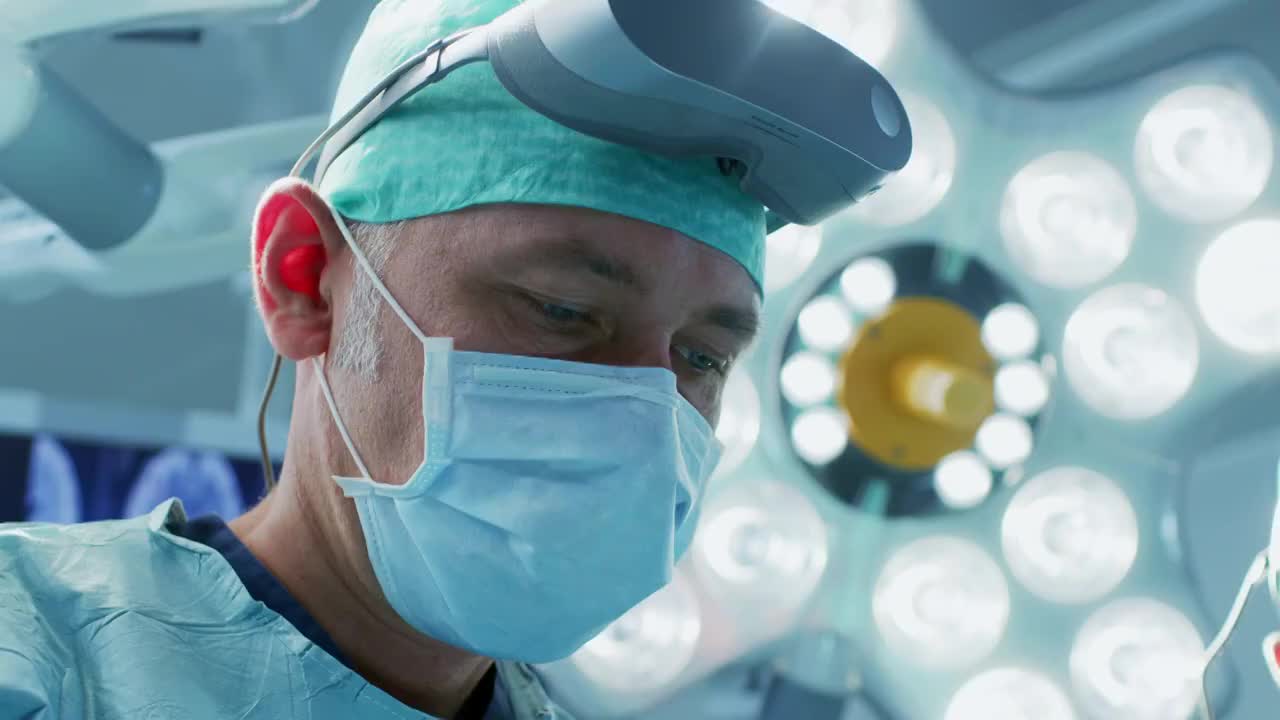 一个外科医生的特写镜头戴上增强现实眼镜在高科技医院执行最先进的外科手术的状态。在手术室工作的医生和助手。视频素材