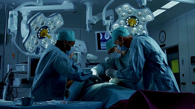 不同的专业外科医生团队在医院手术室对病人进行侵入性手术。外科医生使用和其他工具。视频素材