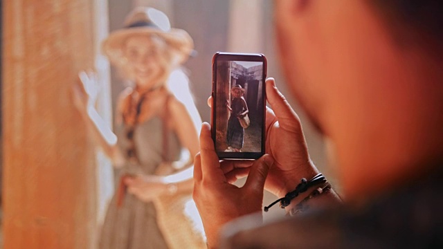 一名男子用智能手机给一名女子拍照视频素材
