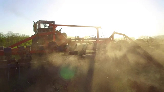 农民在拖拉机土壤犁稳定的运动农业地面俄罗斯准备土地与苗床耕作机作为预播种活动的一部分，在早春季节的生活方式农业工作在农田。农业的概念视频素材