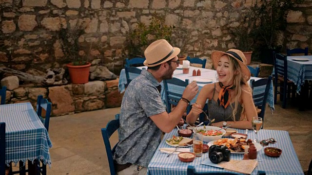 年轻的游客夫妇在希腊小酒馆吃得很开心视频素材