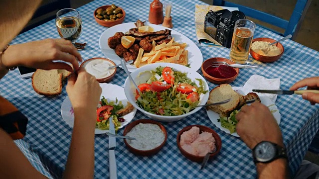 年轻的游客夫妇在传统的希腊餐馆吃午餐视频素材