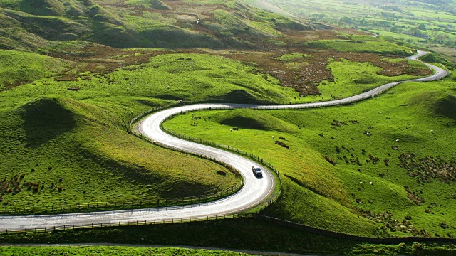 阳光反射在壮观的弯曲的道路在英国峰区视频素材