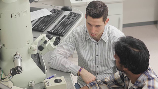 两位大学研究人员在计算机上检查科学样本并进行讨论视频下载