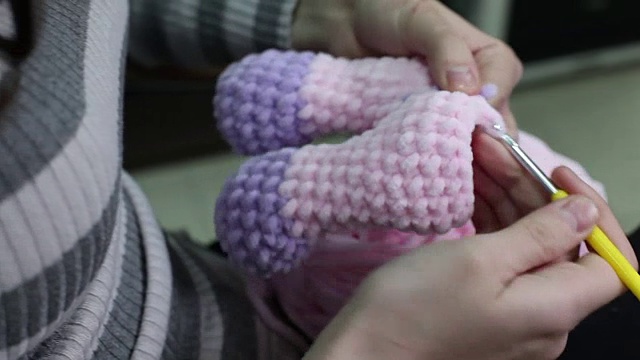 这个女孩编织了一个玩具。爱好制作手工针织品视频素材
