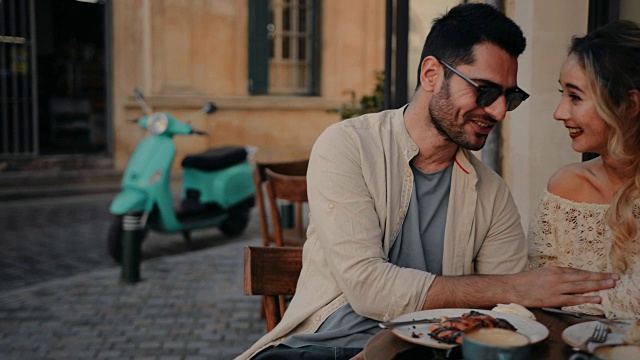 一对年轻的游客夫妇在意大利的一家咖啡馆里吃早餐视频下载