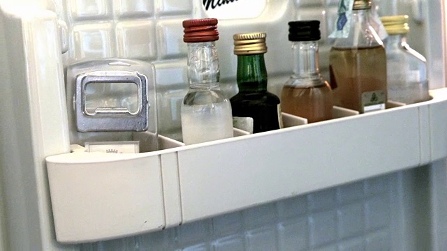从酒店的小酒柜里拿了一瓶酒视频素材