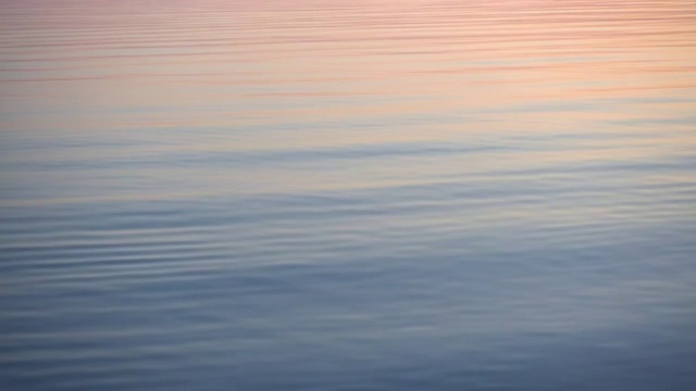壮丽的落日映照在平静的水面上。视频素材