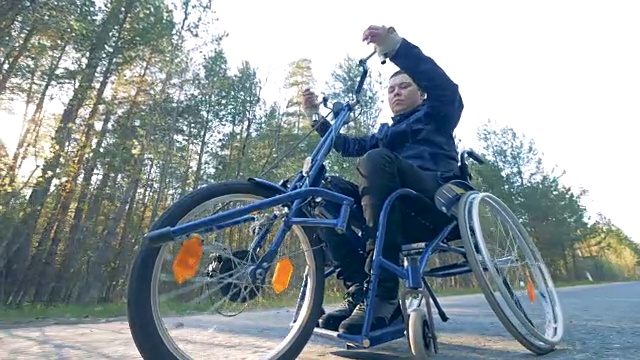 一个男人骑着医疗自行车，从下往上看。视频素材