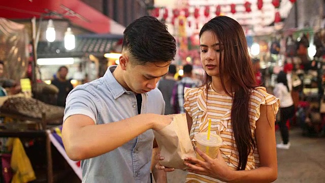 一对夫妇在Jalan Petaling市场吃街边小吃视频下载
