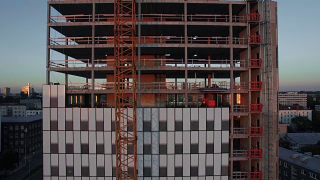 航拍的摩天大楼在建设过程中。工作起重机与现代城市的背景。视频素材