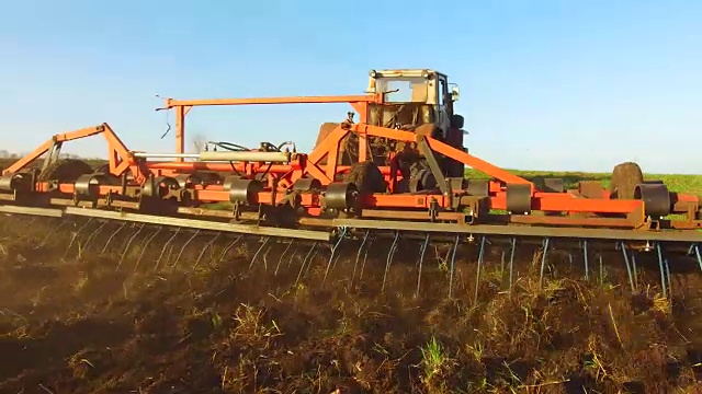 农民在拖拉机土壤犁俄罗斯稳定运动农业地面准备土地与苗床中耕机作为农业工作的提前播种活动的一部分在农田的早春季节。农业生活方式的概念视频素材