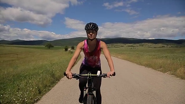 女自行车手穿着专业的自行车服和头盔骑自行车视频购买