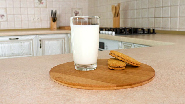近距离的一杯牛奶与健康的麦片饼。以白色厨房为背景的旋转相机。Dolly-shot。视频素材