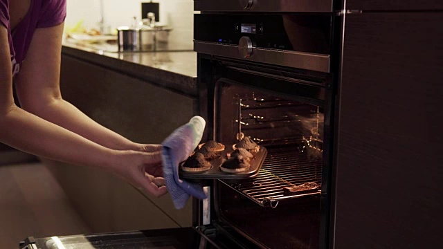 女人的手打开烤箱，拿起烧焦的饼干，炊烟飘来视频素材