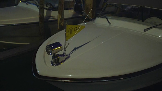 白色小船出租车在水上摇摆，威尼斯独特的交通工具，夜间视频素材