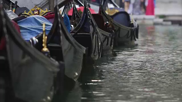 贡多拉排成一排，在水面上摇摆，为威尼斯的游客提供复古的出租车视频素材