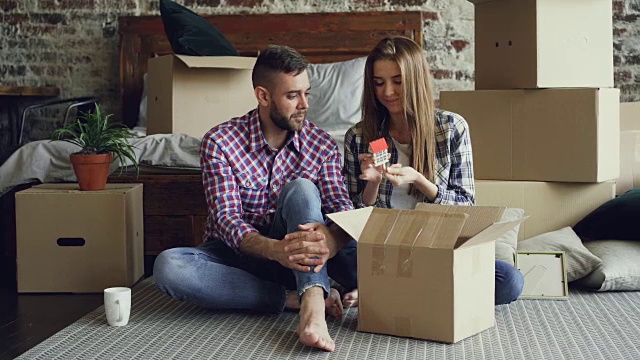 兴奋的年轻夫妇正在拆东西，打开盒子，拿个人物品，在搬到新公寓后交谈。关系和搬迁概念。视频素材