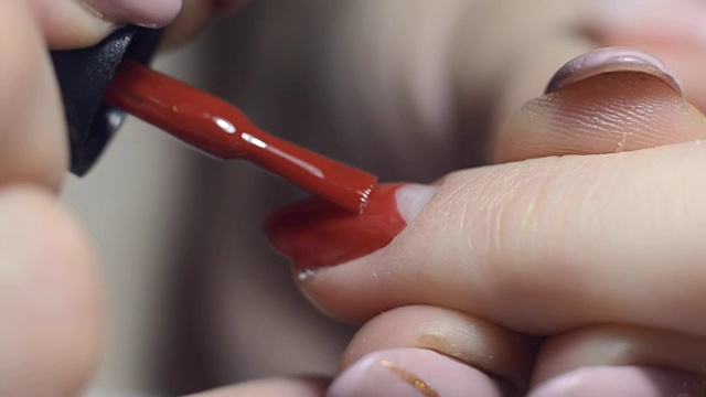 美甲师在沙龙里用红漆涂指甲视频素材