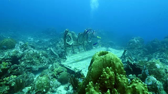 飞机残骸作为珊瑚礁的一部分，在加勒比海库拉索岛周围的蓝色背景视频素材