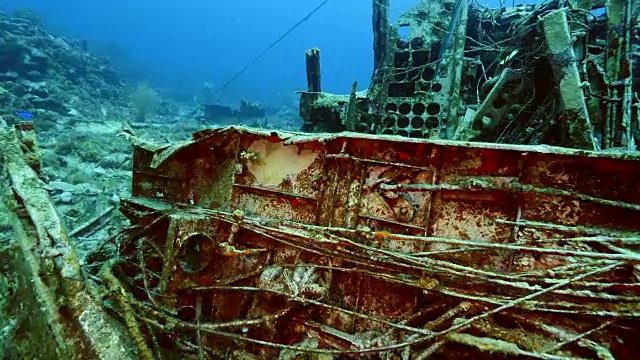 飞机残骸作为珊瑚礁的一部分，在加勒比海库拉索岛周围的蓝色背景视频素材