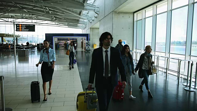 多民族旅行者提着行李箱在国际机场行走视频下载
