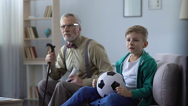 爷爷和孙子在家里一起看足球，伤心极了视频素材
