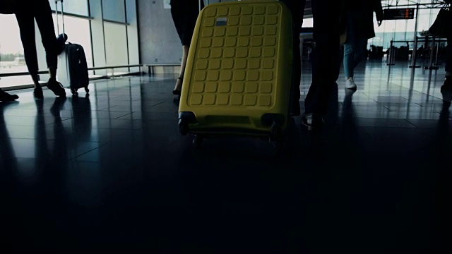 带着行李的旅客在机场走廊上向候机楼门口走去视频素材