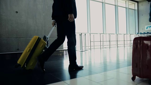 商人和其他乘客带着行李在机场行走视频素材