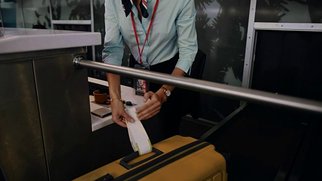 年轻的空乘人员正在把标签贴在旅行箱上视频下载