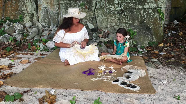 拉罗汤加库克群岛，一名太平洋岛民向一名女游客展示如何编织一把手扇子视频下载