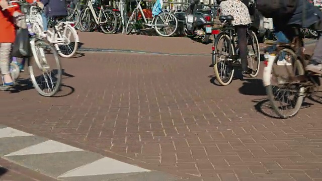 阿姆斯特丹狭窄的街道上骑自行车的行人。在欧洲，许多自行车和行人都是环保的交通工具。不知名的人视频素材
