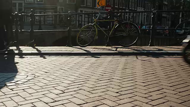 在Amesterdem的一座狭窄的桥上有很多自行车和行人。在画面中，你可以看到自行车轮子和步行的行人——一个激烈的运动。这里是欧洲的自行车之都视频素材