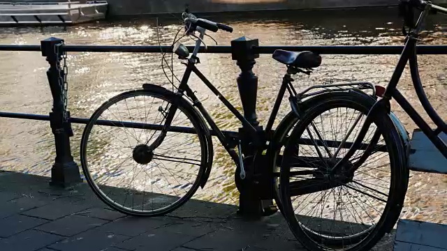 运河岸边的交通自行车。自行车的剪影。荷兰阿姆斯特丹视频素材