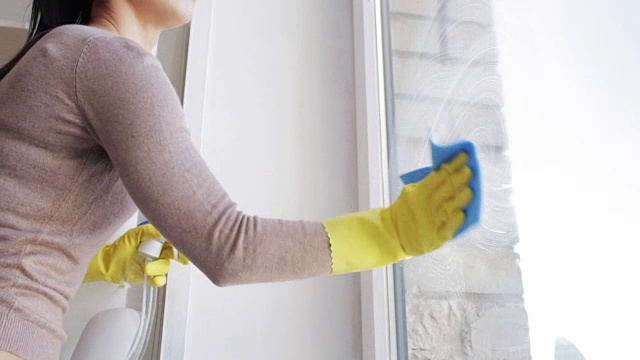 戴着手套用抹布擦窗户的女人视频素材