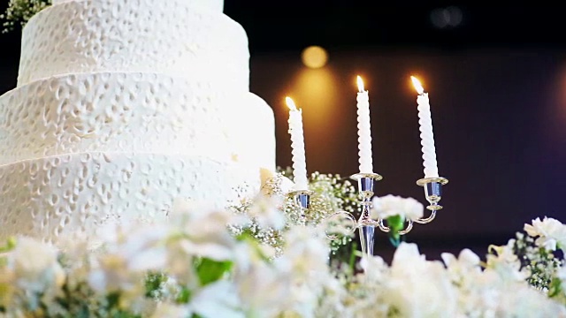 美丽的婚礼蛋糕装饰鲜花和蜡烛在婚宴上。视频素材
