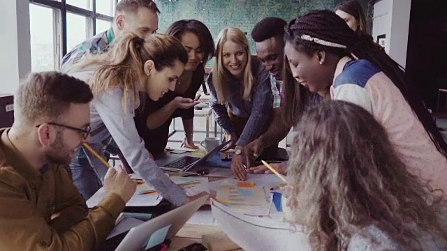 近距离观察年轻的商业团队与女性团队领导一起工作在桌子附近，积极的头脑风暴视频素材
