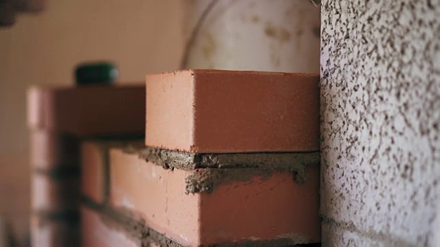 手工砌砖工艺。一个建筑工人正在一块一块地砌砖视频素材
