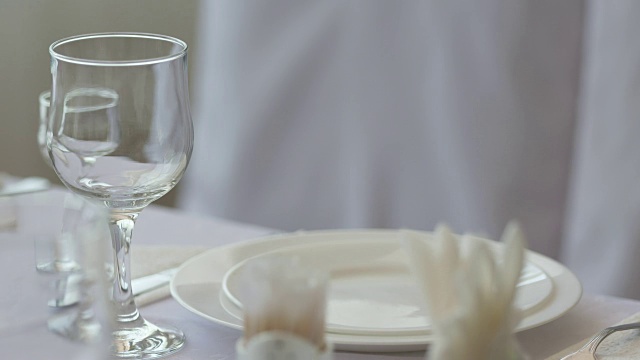 精致的餐桌设置在餐厅的盘子，刀叉和高脚餐具视频素材