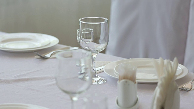 精致的餐桌设置在餐厅的盘子，刀叉和高脚餐具视频下载