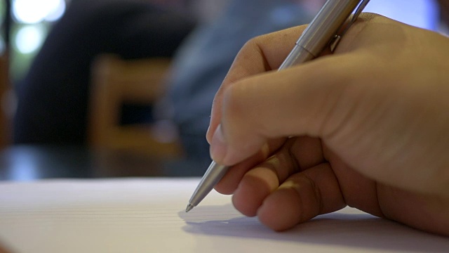 男人在纸上写字，特写。视频素材