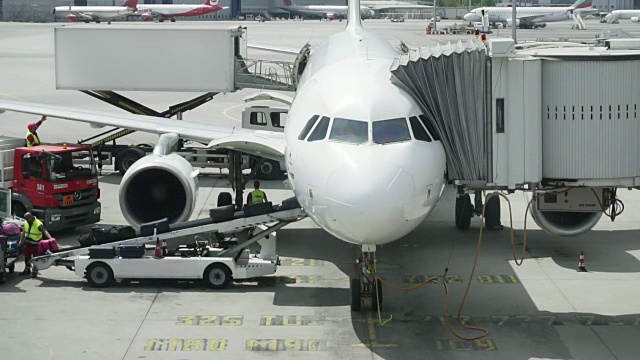 机场工作人员在飞机传送带上携带行李。工作人员将行李装上客机。慢镜头，特写视频素材