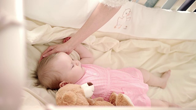 婴儿睡眠时间。蹒跚学步的小女孩在婴儿床上休息。小婴儿在婴儿床里做梦视频下载