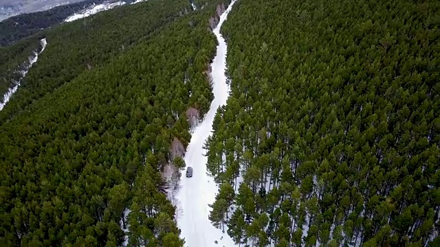 在雪地上行驶的汽车，由无人机拍摄视频下载