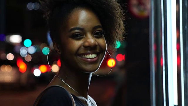 非洲裔年轻女子在夜晚的城市画像视频素材